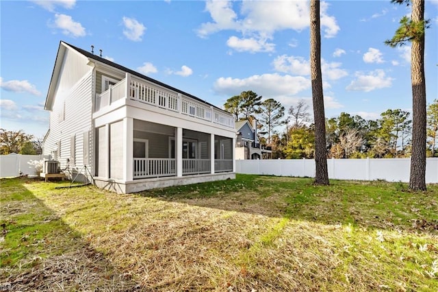 back of house with a sunroom, cooling unit, and a lawn