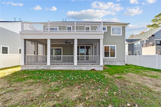 back of house with a balcony, a lawn, a sunroom, and ceiling fan