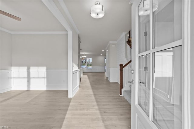 foyer entrance featuring ornamental molding, a chandelier, and light wood-type flooring