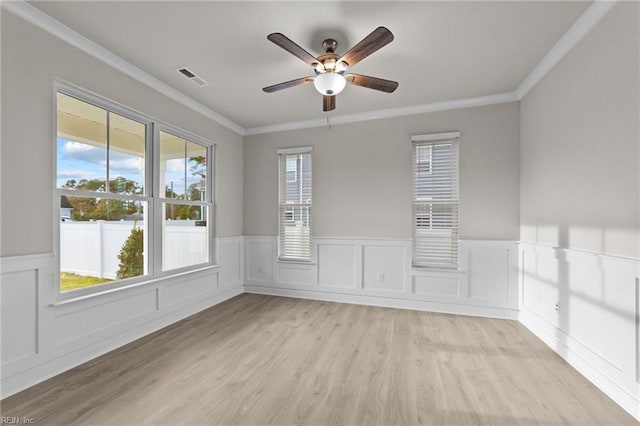 empty room with ceiling fan, ornamental molding, and light hardwood / wood-style floors