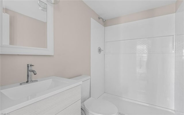 bathroom with vanity, walk in shower, and toilet