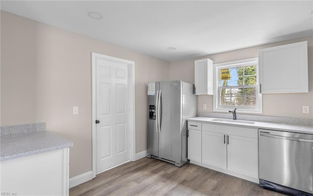 kitchen featuring white cabinetry, sink, light hardwood / wood-style flooring, and stainless steel appliances