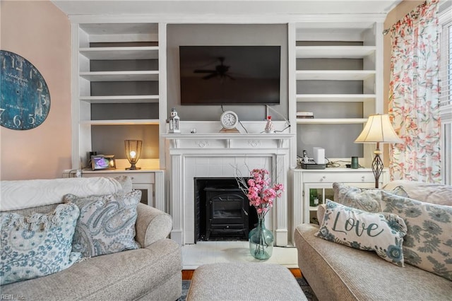 living room with built in shelves and ceiling fan