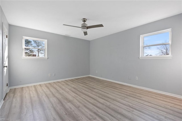 empty room with ceiling fan and light hardwood / wood-style flooring