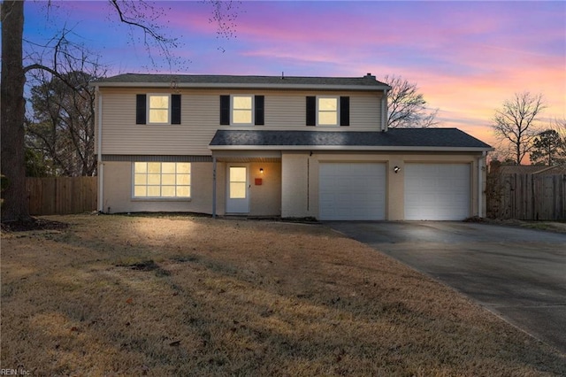 front of property with a garage and a lawn