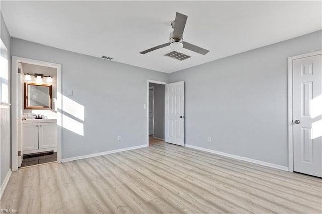 unfurnished bedroom featuring ensuite bathroom, sink, ceiling fan, and light hardwood / wood-style floors