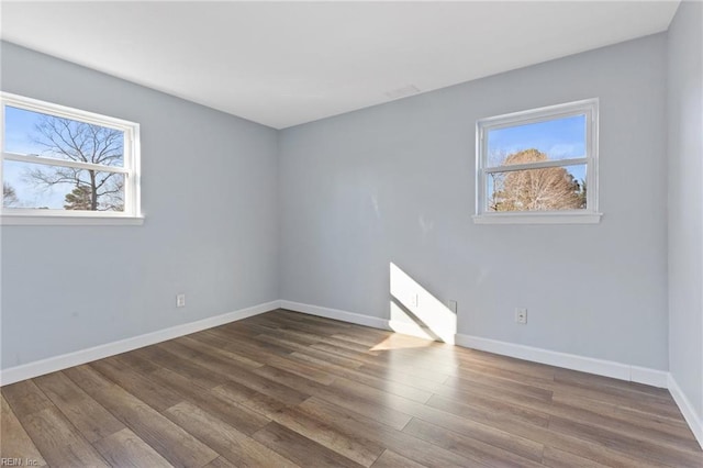 spare room featuring plenty of natural light and hardwood / wood-style floors