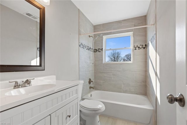 full bathroom featuring vanity, toilet, and tiled shower / bath