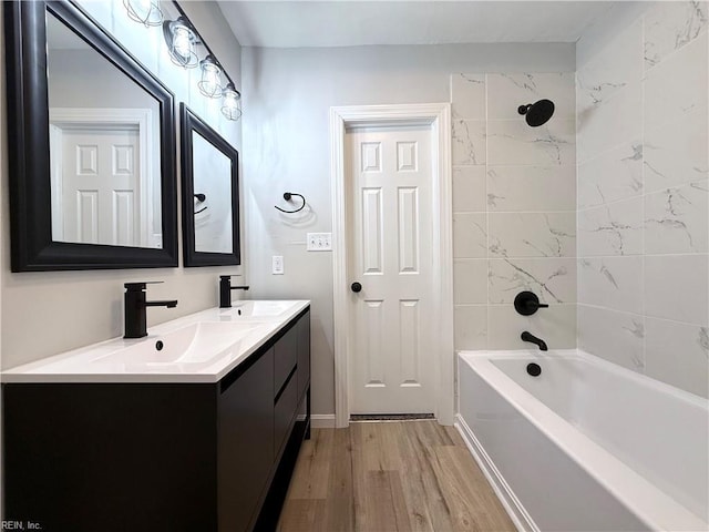 bathroom with vanity, hardwood / wood-style floors, and tiled shower / bath combo