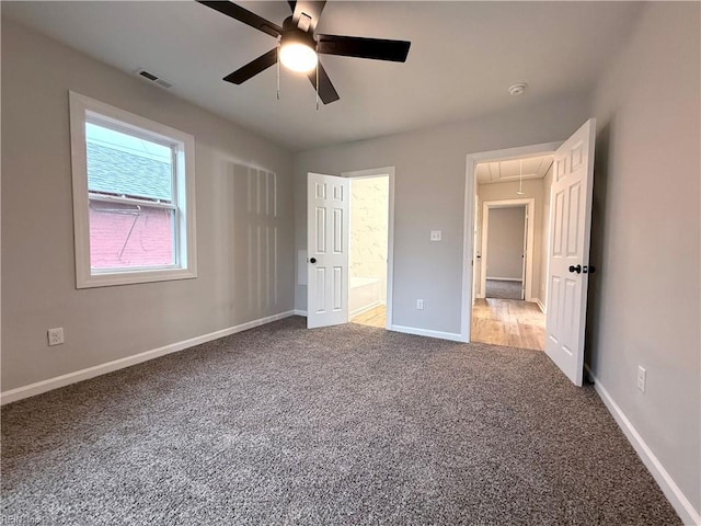 unfurnished bedroom featuring carpet floors, ceiling fan, and ensuite bathroom