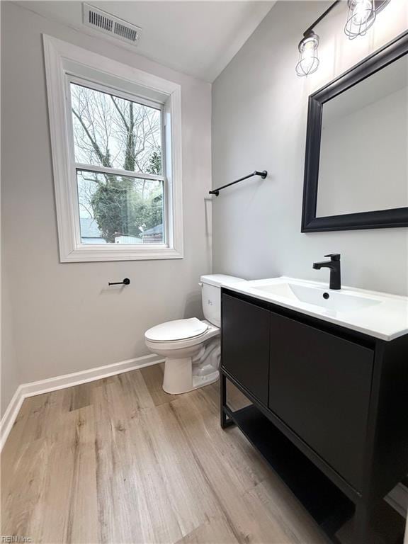 bathroom with vanity, vaulted ceiling, hardwood / wood-style floors, and toilet