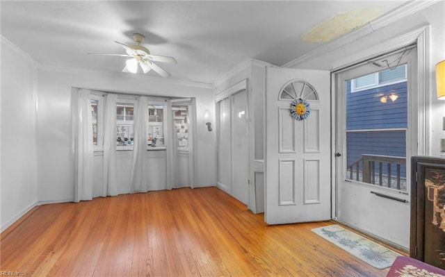 foyer with ornamental molding, ceiling fan, and light hardwood / wood-style flooring