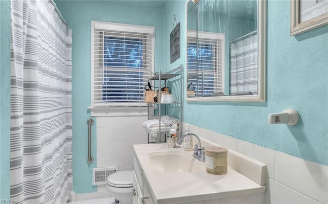 bathroom featuring vanity, tile walls, curtained shower, and toilet