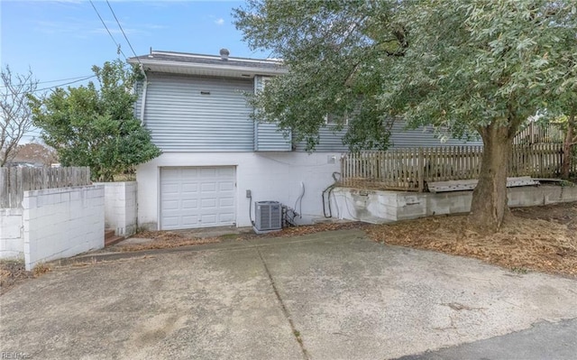 rear view of house with a garage and central air condition unit