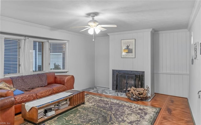 living room featuring hardwood / wood-style flooring, crown molding, and ceiling fan