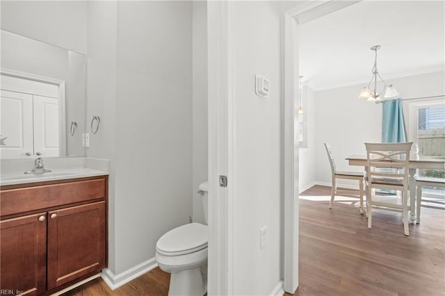 bathroom with crown molding, wood-type flooring, toilet, and vanity