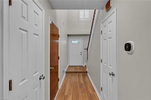 corridor with a wealth of natural light and light hardwood / wood-style flooring