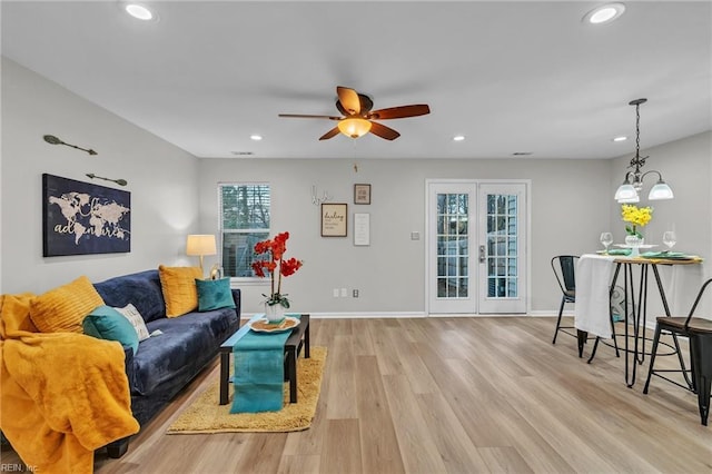 living room featuring ceiling fan, light wood-type flooring, and french doors