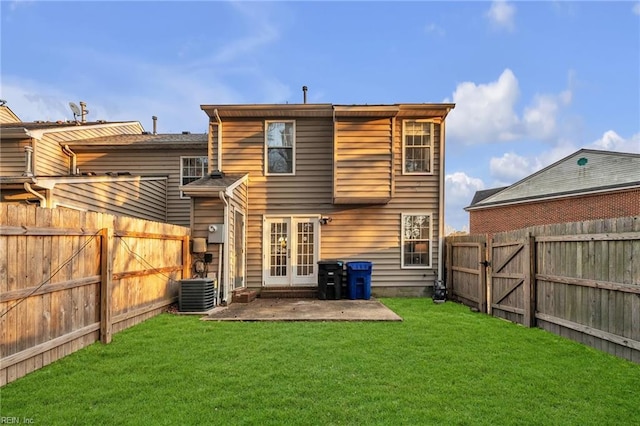 rear view of property featuring french doors, a yard, a patio area, and central air condition unit