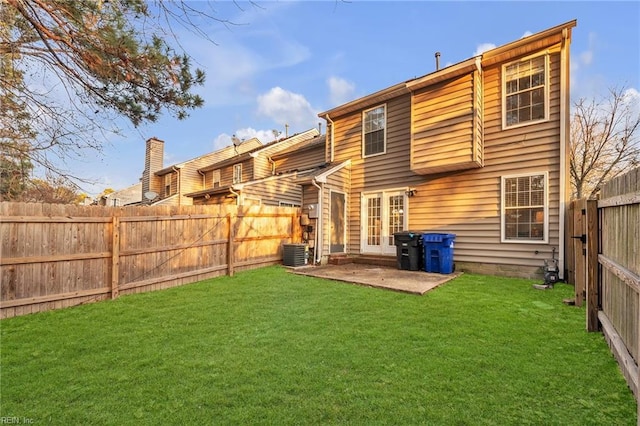 rear view of house featuring cooling unit, a yard, and a patio area