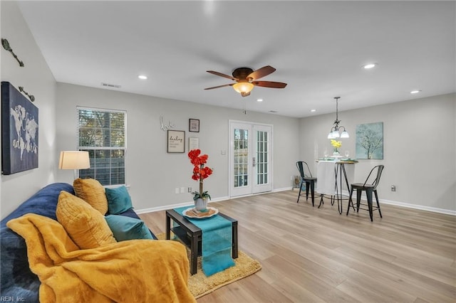 living room featuring french doors, ceiling fan, and light wood-type flooring