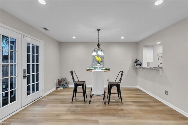 dining area featuring french doors and light wood-type flooring