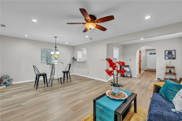 living room with ceiling fan and light hardwood / wood-style floors