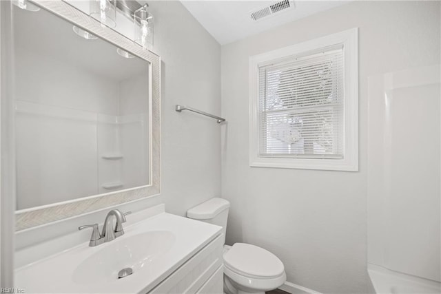 bathroom with vanity, a shower, and toilet