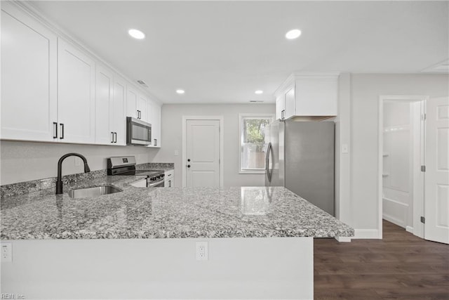 kitchen featuring sink, white cabinets, kitchen peninsula, stainless steel appliances, and light stone countertops