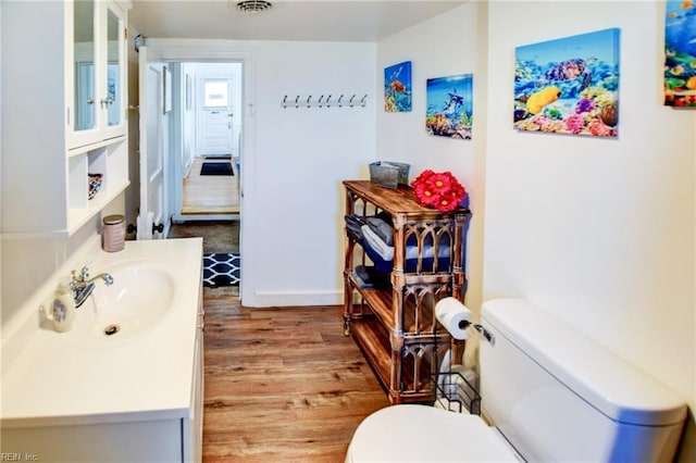 bathroom featuring hardwood / wood-style flooring, vanity, and toilet