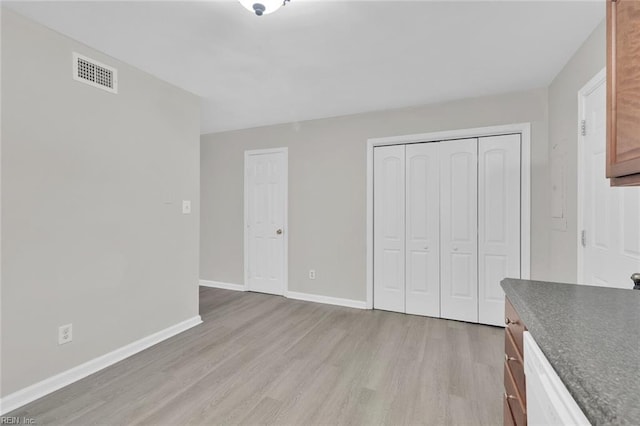 unfurnished bedroom with light hardwood / wood-style floors and a closet