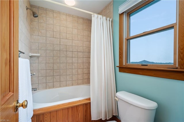 bathroom featuring shower / tub combo with curtain, toilet, and a wealth of natural light