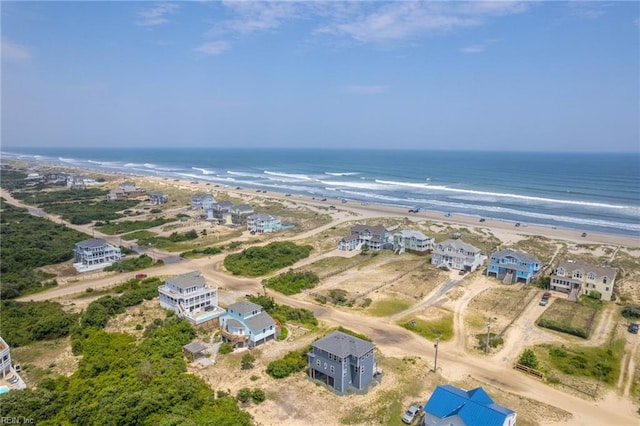 bird's eye view featuring a water view and a beach view