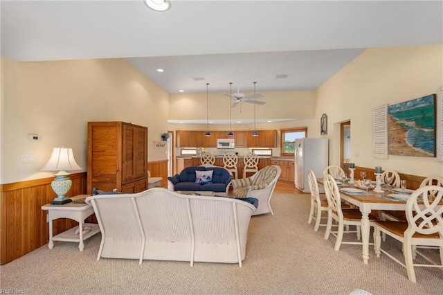 carpeted living room with wooden walls and ceiling fan