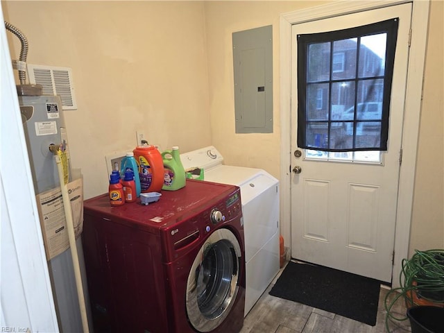 laundry room with water heater, hardwood / wood-style floors, electric panel, and washer and clothes dryer