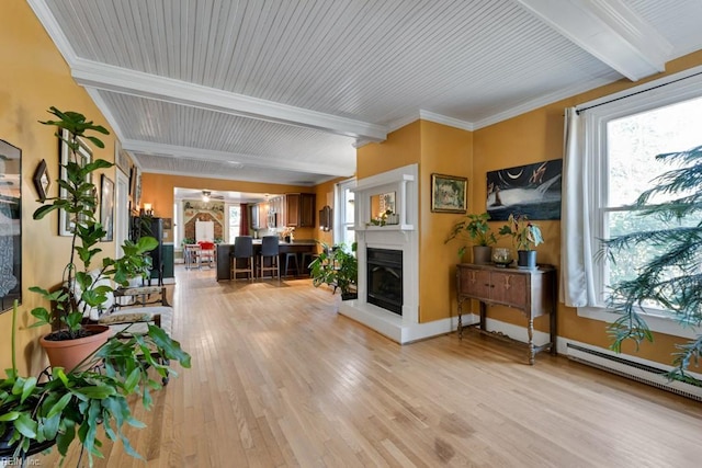 interior space featuring a baseboard heating unit, beam ceiling, light hardwood / wood-style flooring, and ornamental molding