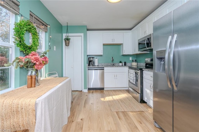 kitchen with white cabinetry, sink, light hardwood / wood-style flooring, and stainless steel appliances