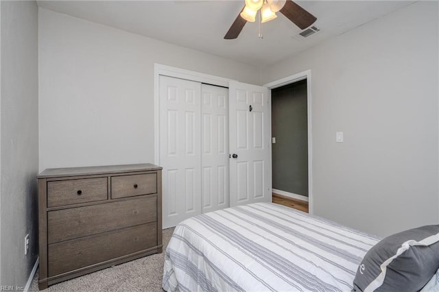 carpeted bedroom with ceiling fan and a closet