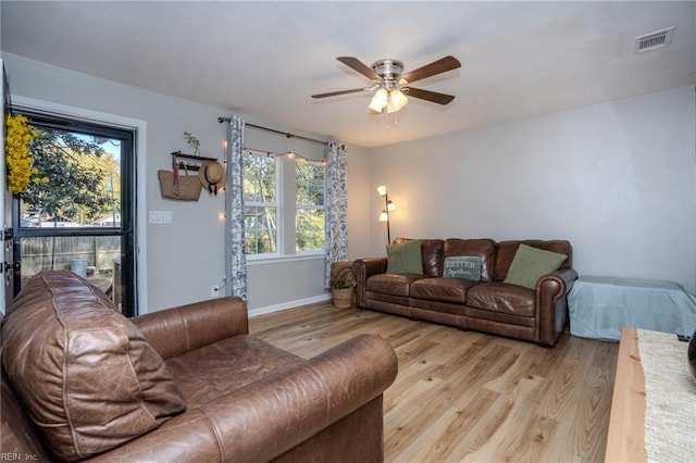 living room with light hardwood / wood-style floors and ceiling fan