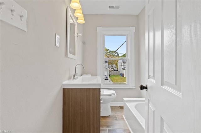 bathroom with vanity, toilet, a bathing tub, and wood-type flooring