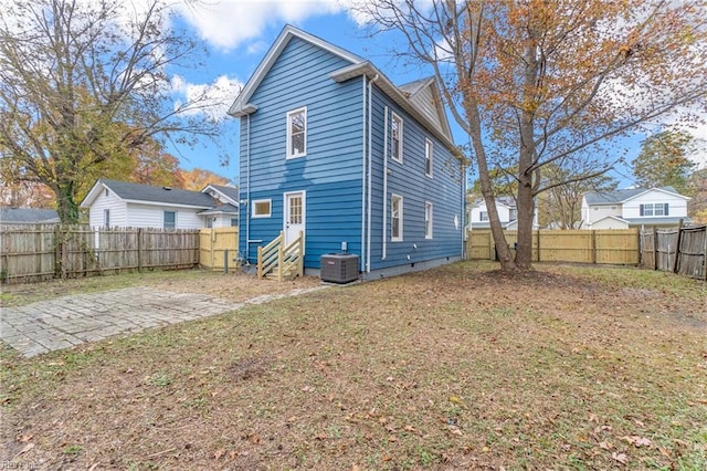 back of house featuring central AC, a yard, and a patio area