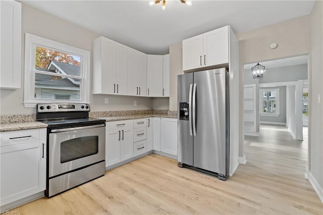 kitchen featuring light stone counters, light wood-type flooring, a notable chandelier, stainless steel appliances, and white cabinets