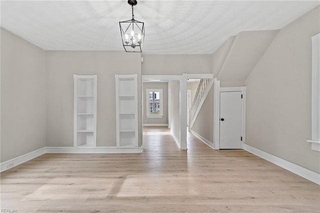 interior space featuring an inviting chandelier and light hardwood / wood-style flooring