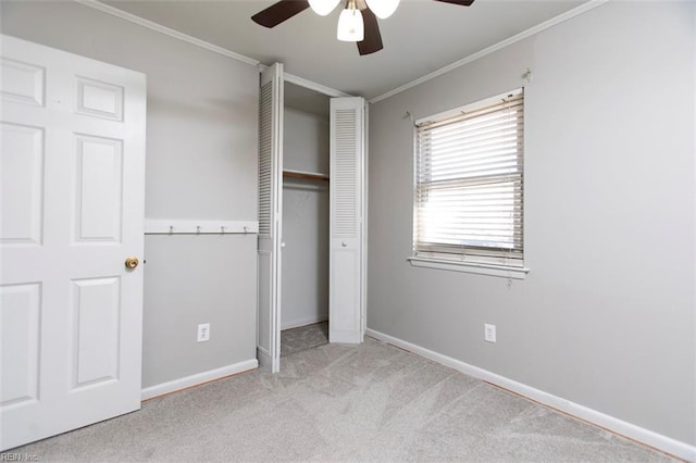 unfurnished bedroom with crown molding, a closet, ceiling fan, and light carpet