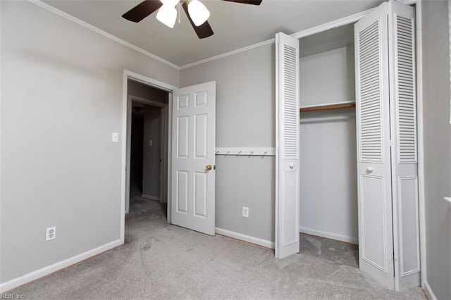 unfurnished bedroom featuring crown molding, light colored carpet, ceiling fan, and a closet