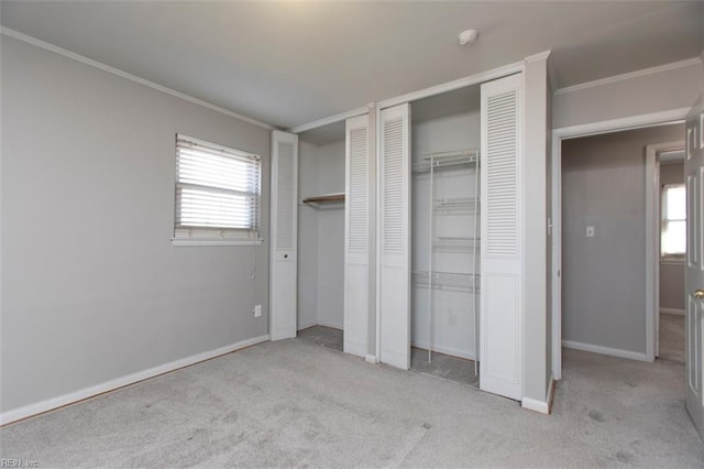 unfurnished bedroom featuring multiple windows, light carpet, and two closets