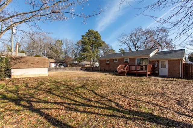 view of yard featuring a wooden deck and a storage shed