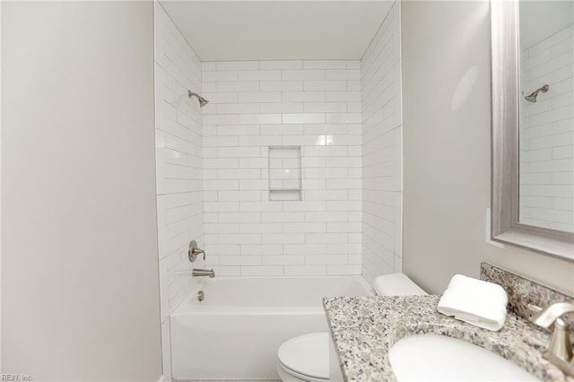 full bathroom with vanity, tiled shower / bath, and toilet