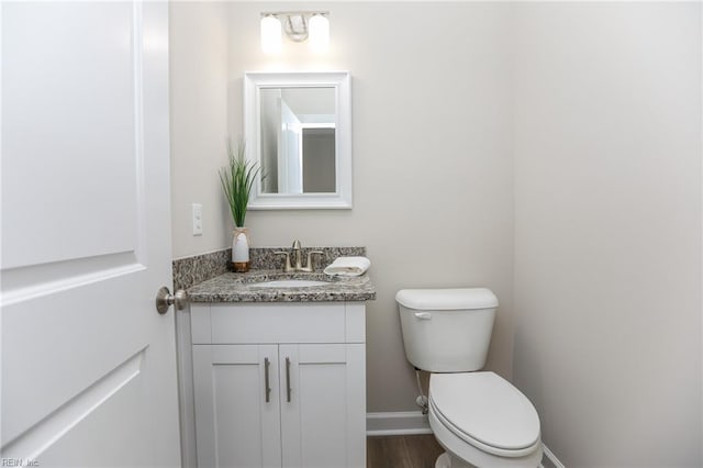 bathroom featuring vanity, hardwood / wood-style flooring, and toilet