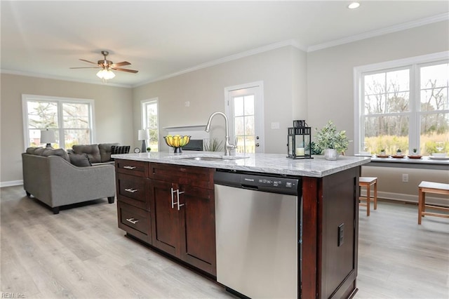 kitchen featuring sink, crown molding, dishwasher, a kitchen island with sink, and light stone counters